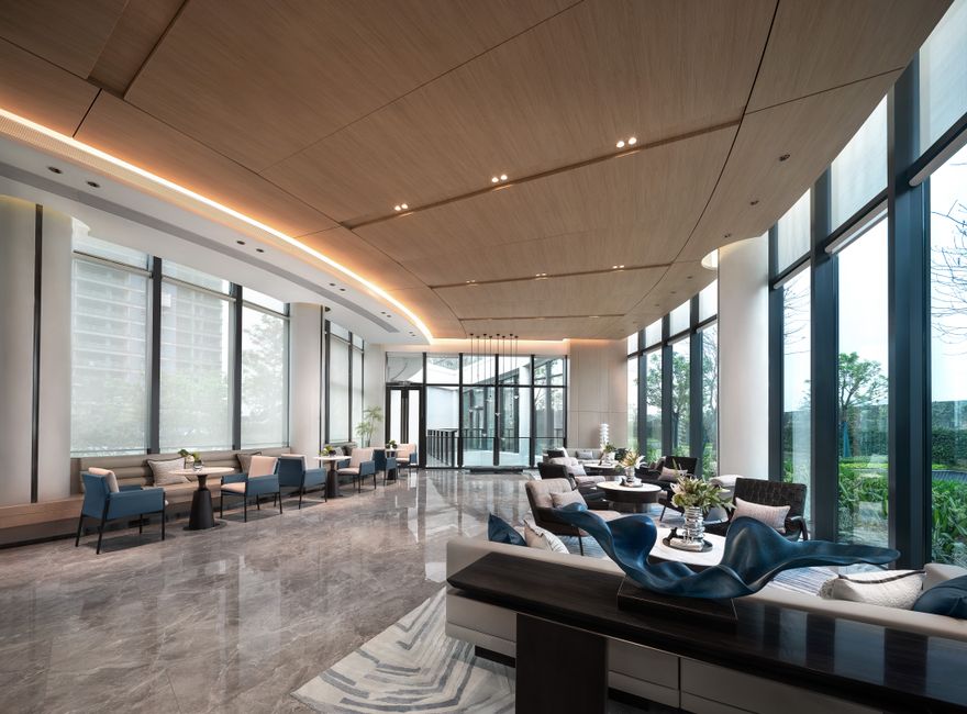 Prostorná lobby moderního hotelu s posezením u prosklené stěny